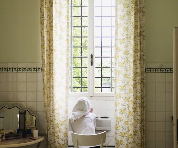 Person sitting calmly in a comfortable chair by the window.